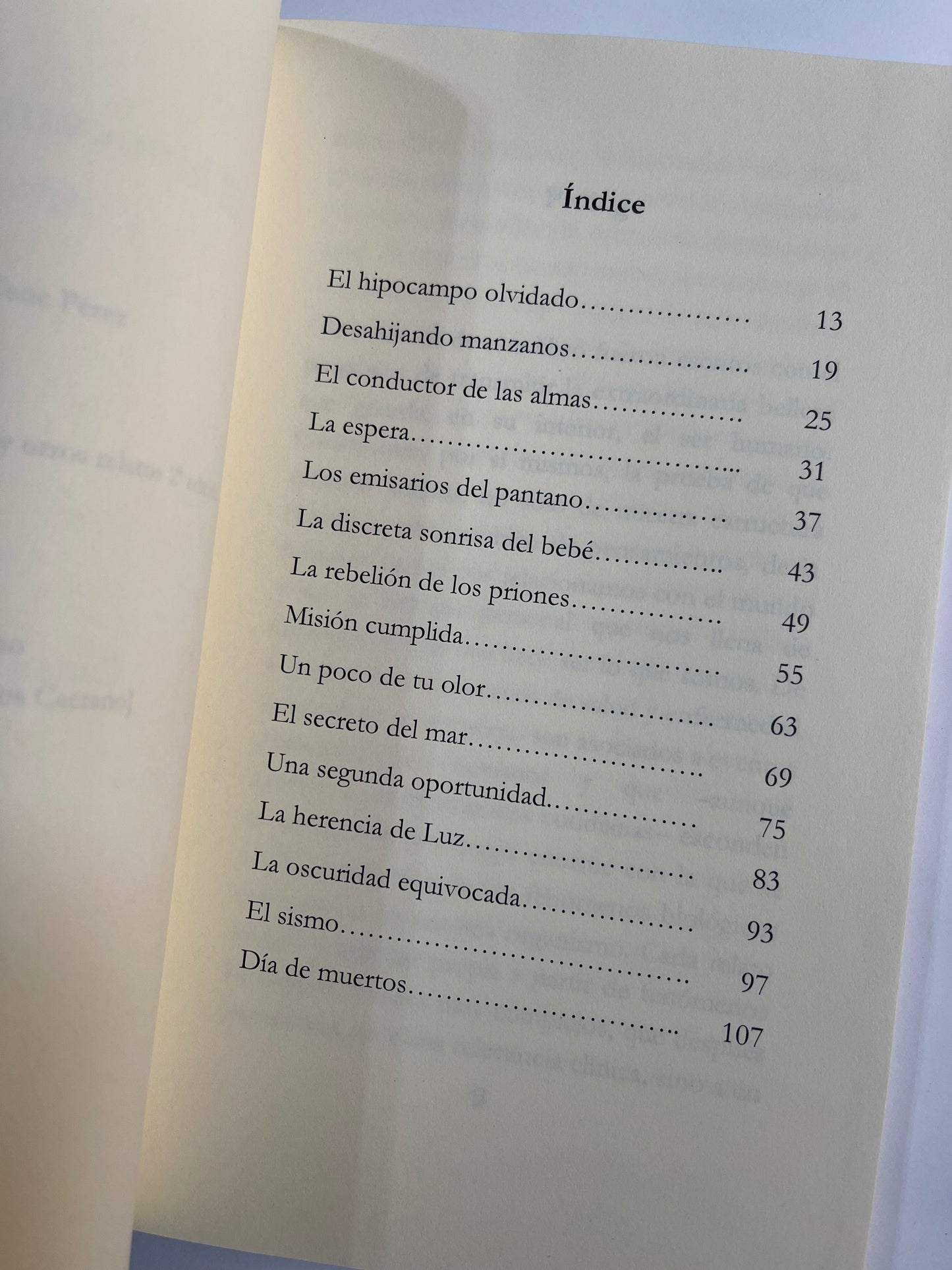 Se muestra el libro semiabierto, donde se aprecia la página del índice y los diferentes capítulos que lo integran: El hipocampo olvidado, en la página 13, Desahijando manzanos, El conductor de las almas, La espera, Los emisarios del pantano, La discreta sonrisa del bebé y La rebelión de los priones, entre otros.